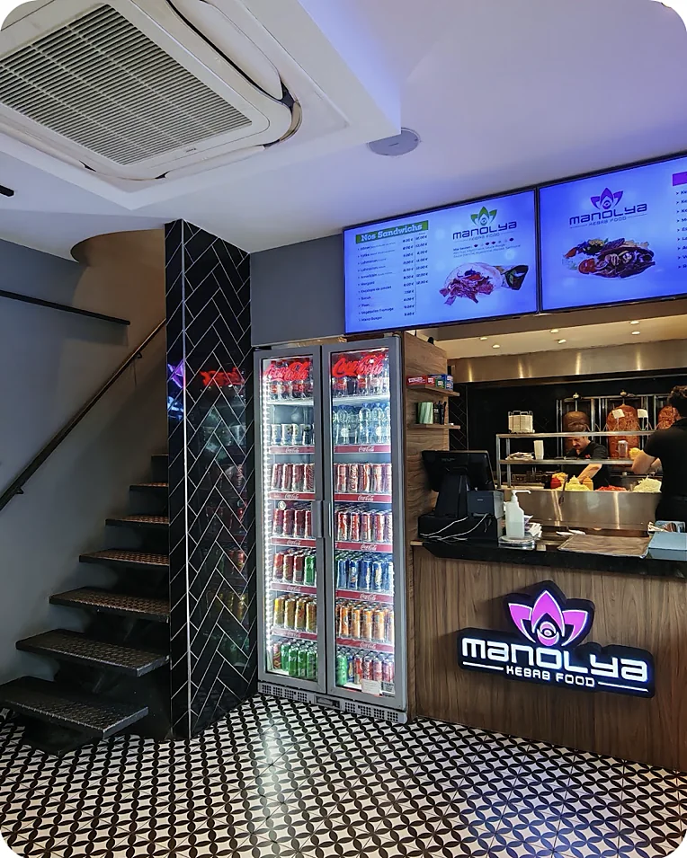 Le comptoir de Manolya, l'enseigne lotus allumée et l'escalier vers l'étage